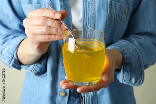 Woman hold spoon and glass of lemon jelly