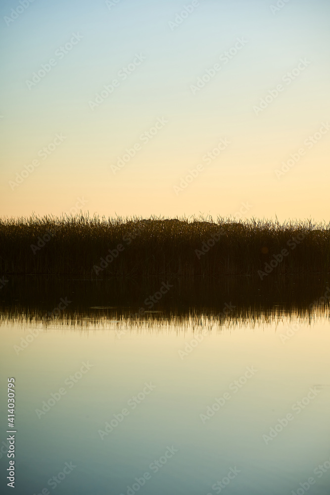 Vertical photo of the landscape of blue river and sky during sunset in the countryside