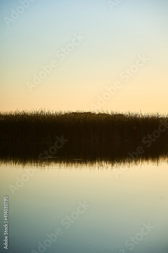 Vertical photo of the landscape of blue river and sky during sunset in the countryside