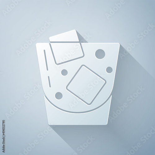 Paper cut Glass of whiskey and ice cubes icon isolated on grey background. Paper art style. Vector.