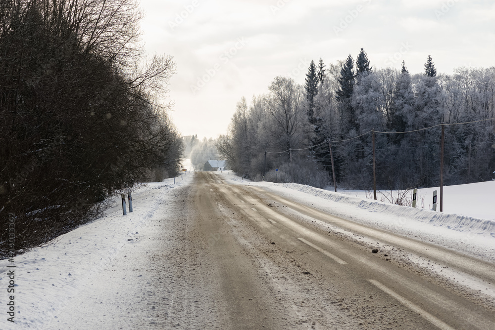 Winter road in snowy forest on a cold day. Winter road in snowy forest on a cold day.