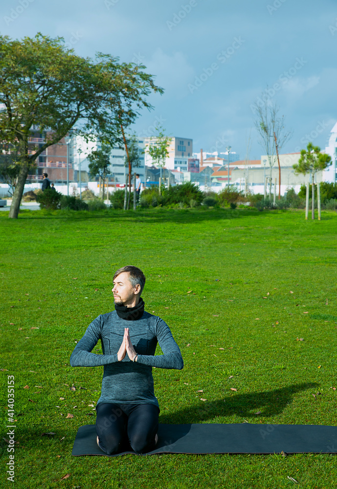 Fototapeta premium Middle aged man doing yoga in the park