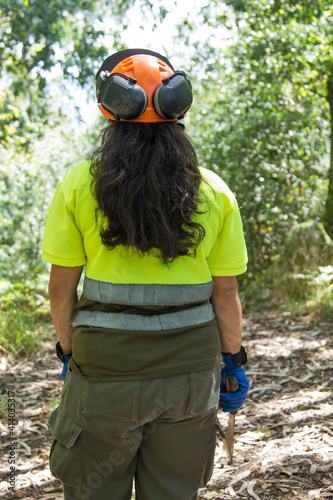 female forest worker or lumberjack with ax to cut trees in forest