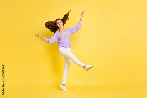 Full length photo of young cheerful girl happy positive smile go walk wear casual outfit isolated over yellow color background