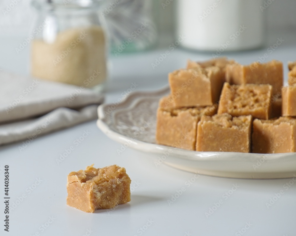 Homemade fudge cut into cubes on plate on white kitchen counter