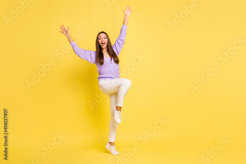 Full body photo of young cheerful girl happy positive smile excited wave hello greetings isolated over yellow color background