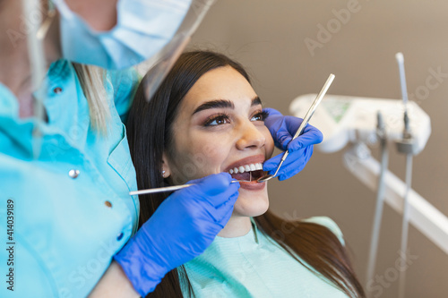 Attractive young woman in stomatology clinic with female dentist. Healthy teeth concept.