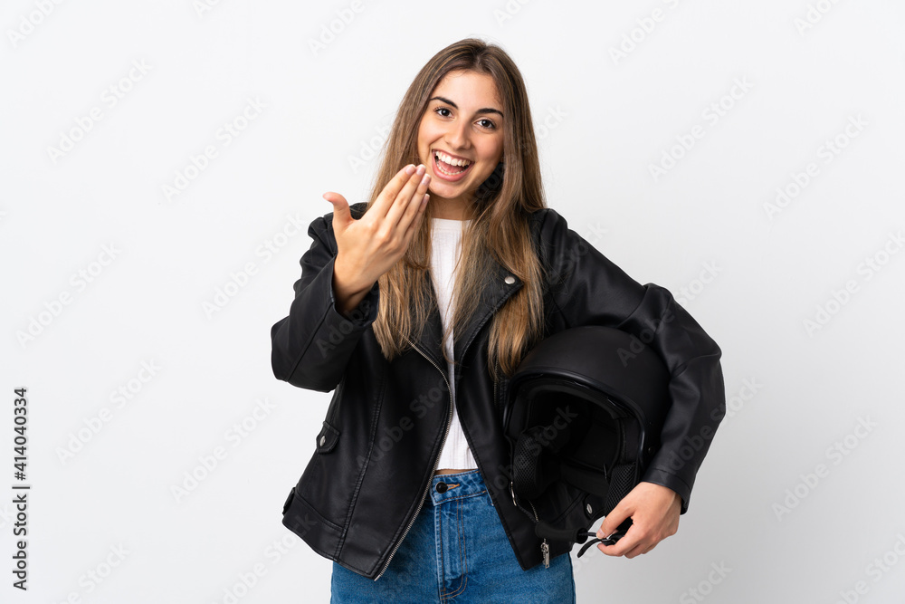 Young Woman holding a motorcycle helmet over isolated white background inviting to come Young Woman holding a motorcycle helmet over isolated white background inviting to come