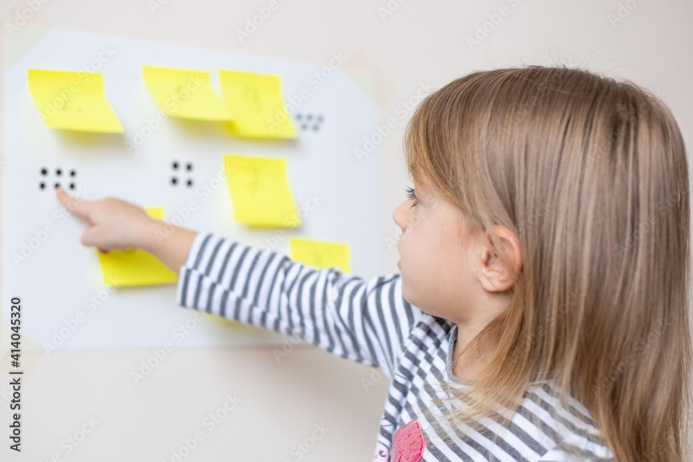 Post it math, a fun addition activity for preschooler.Little girl playing mathematics game at home. Home education.