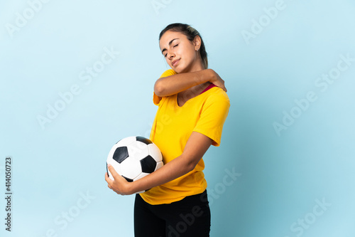 Young hispanic football player woman over isolated on blue background suffering from pain in shoulder for having made an effort © luismolinero