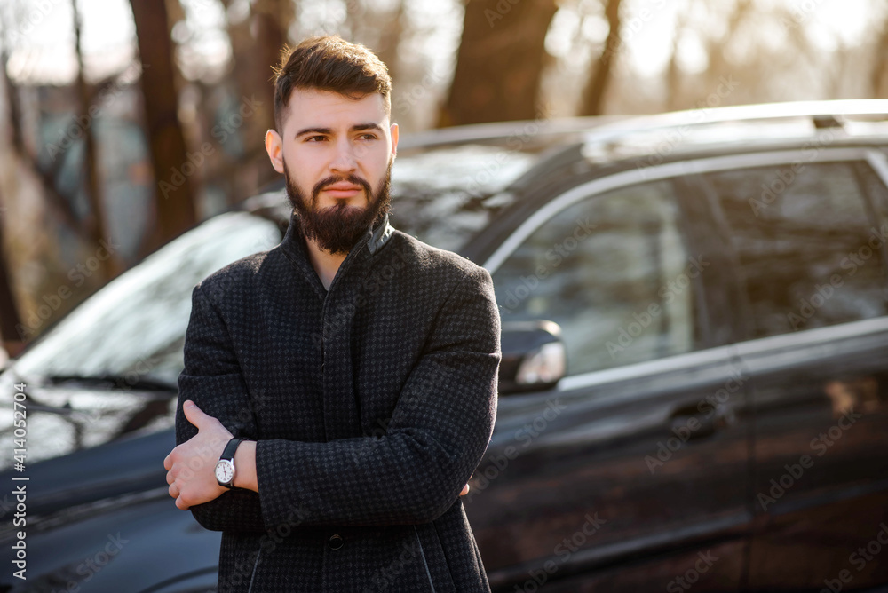 Portrait of bearded stylish young handsome man in black coat outside. Portrait of bearded stylish young handsome man in black coat outside.