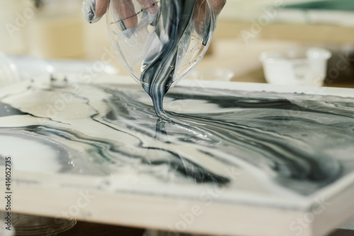 at the fluid art workshop, colored resin is poured onto resin art painting photo