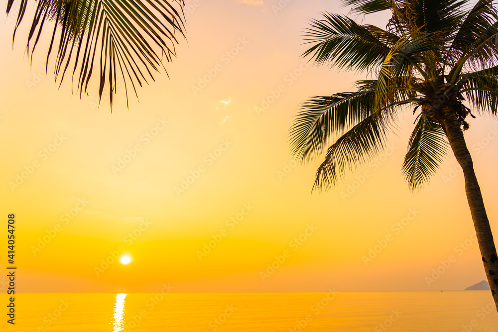 Coconut palm tree around sea beach ocean at sunset or sunrise