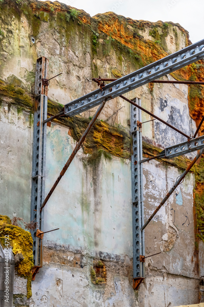 Steel beams supporting the old mossy wall of the building Steel beams supporting the old mossy wall of the building