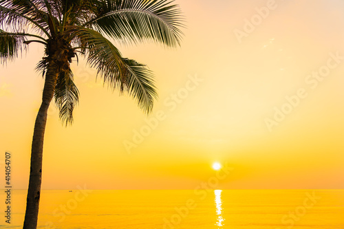 Coconut palm tree around sea beach ocean at sunset or sunrise © siraphol