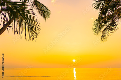 Coconut palm tree around sea beach ocean at sunset or sunrise © siraphol