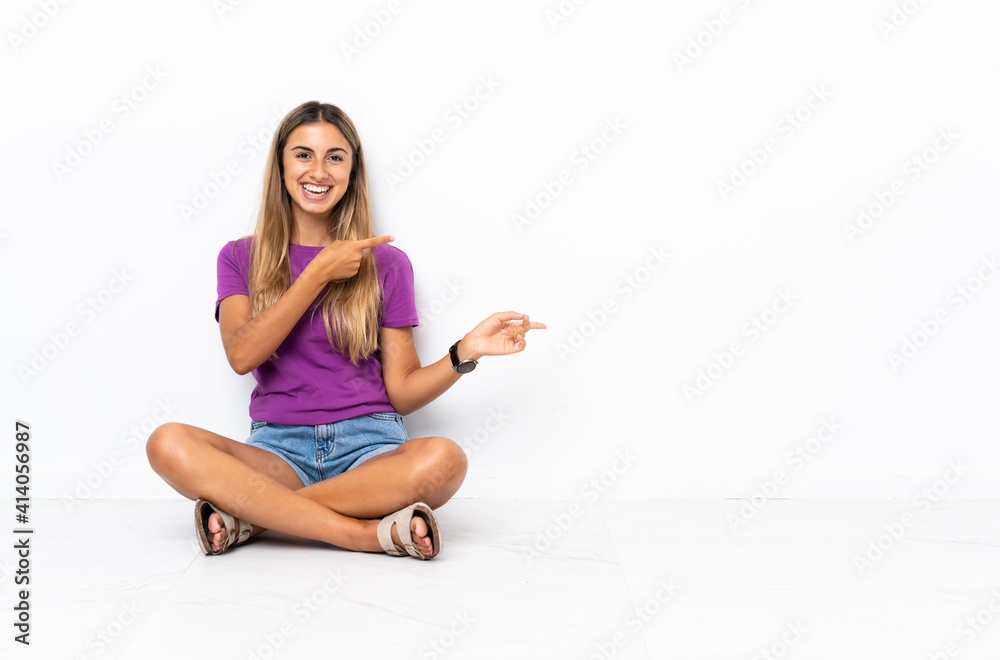 Young hispanic woman sitting on the floor pointing finger to the side Young hispanic woman sitting on the floor pointing finger to the side