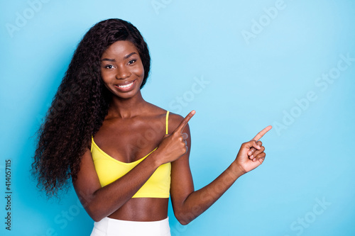 Portrait of pretty cheerful wavy-haired girl showing copy space ad isolated over bright blue color background