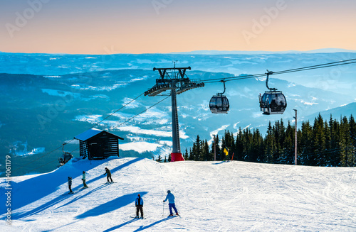 View of the ski lift, slopes and mountains at a Norwegian ski resort on a sunny winters evening.