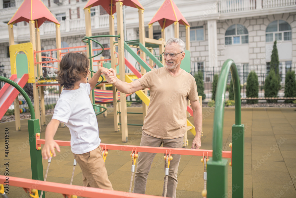 Obraz premium Father and son at the playground together