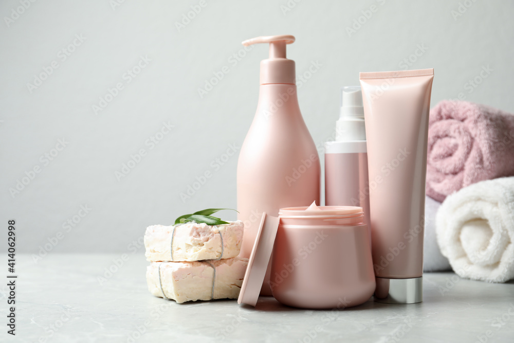 Set of hair care cosmetic products and soap bars on light grey marble table. Space for text Set of hair care cosmetic products and soap bars on light grey marble table. Space for text