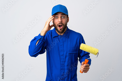 Painter man holding a paint roller isolated on white background has realized something and intending the solution
