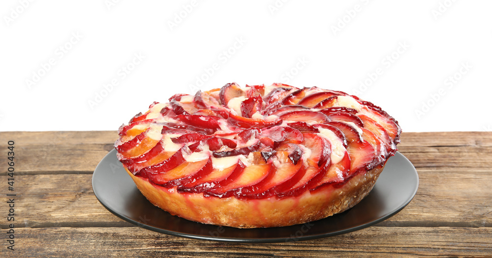 Delicious plum cake on wooden table against white background Delicious plum cake on wooden table against white background