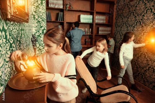 Fotografia Group of young friends trying to find solution of quest in escape room with anti