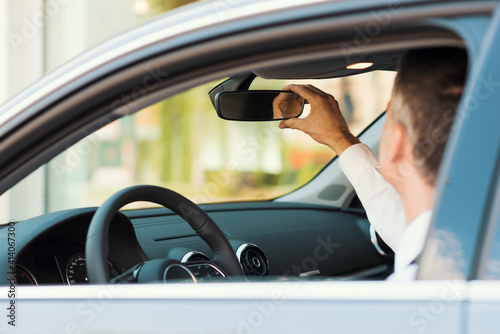 Man adjusting a rearview mirror photo