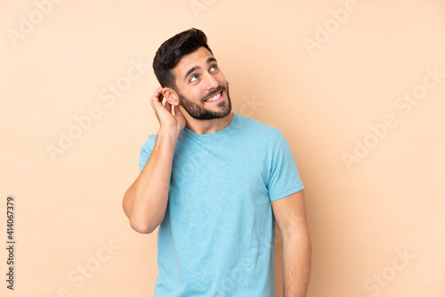 Caucasian handsome man isolated on beige background thinking an idea