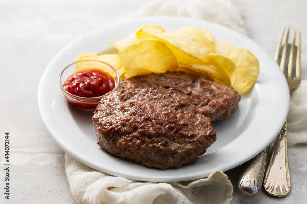 fried ground meat with tomato sauce and potato chips on dish