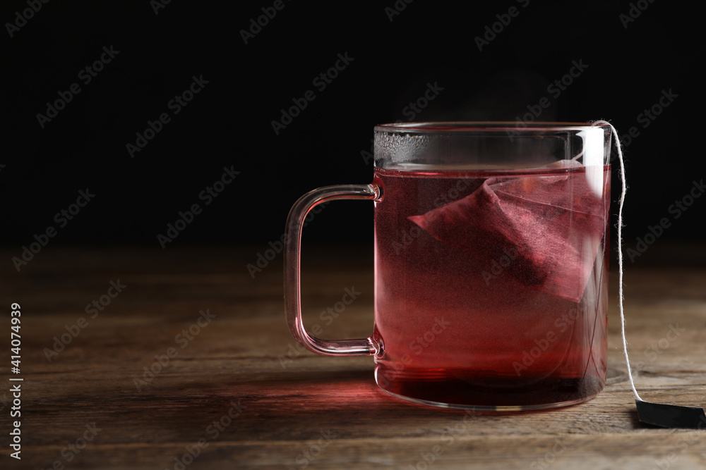 Tea bag in cup of hot water on wooden table. Space for text Tea bag in cup of hot water on wooden table. Space for text