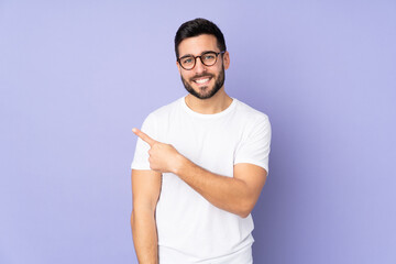 Caucasian handsome man over isolated background pointing to the side to present a product