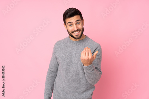 Caucasian handsome man over isolated background inviting to come with hand. Happy that you came photo
