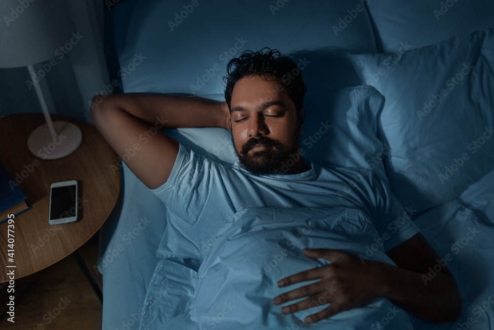 © Syda Productions - people, bedtime and rest concept - indian man sleeping in bed at home at night