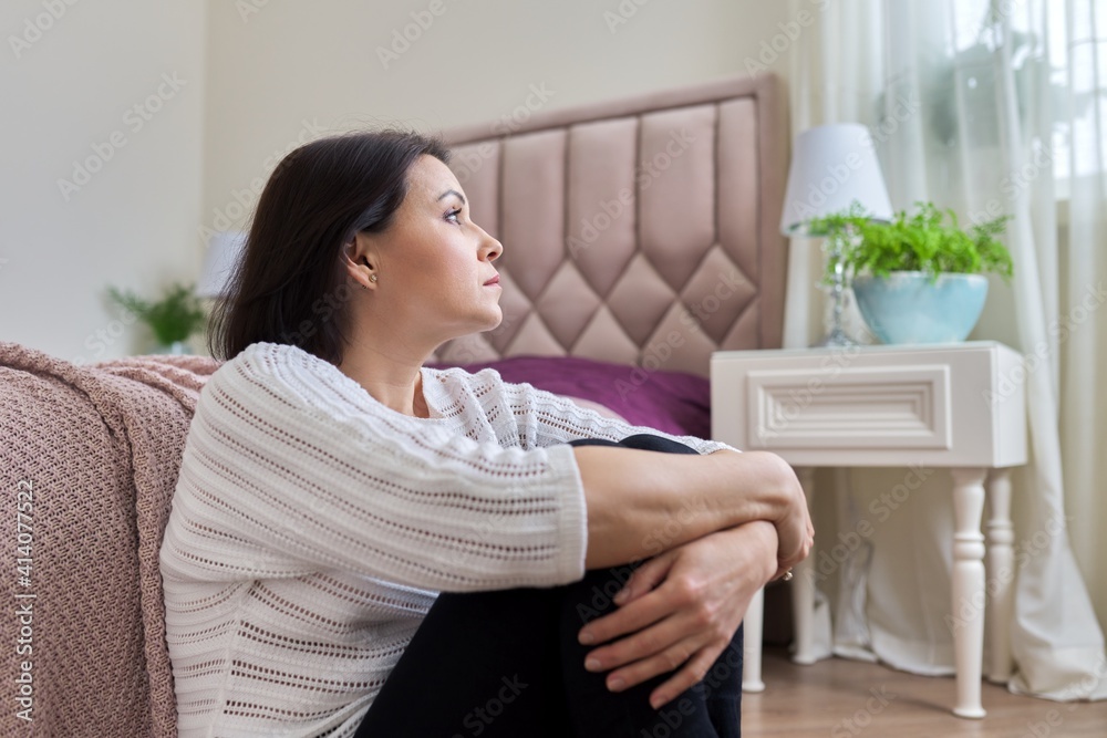 Sad, frustrated, depressed mature woman sitting at home on the floor Sad, frustrated, depressed mature woman sitting at home on the floor