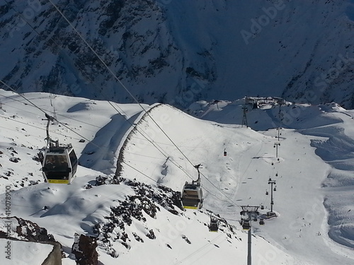 Winter panoramic view of the snowy high mountains of Elbrus and cableway with funicular, ski resort, the Republic of Kabardino-Balkaria, Russia