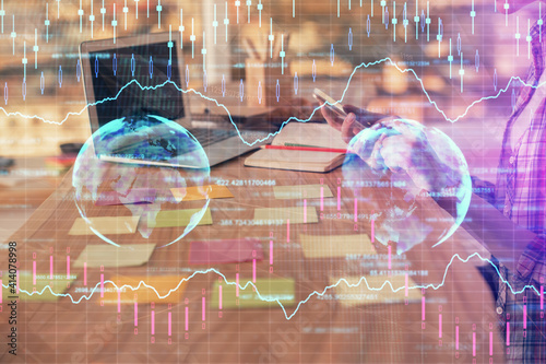 Double exposure of woman hands working on computer and forex graph hologram drawing. Financial analysis concept.