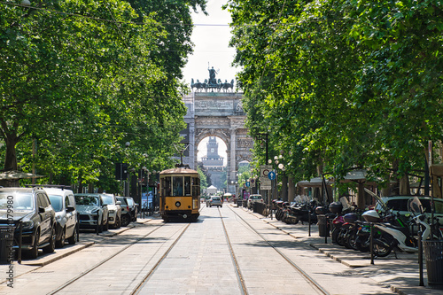 An old traditional tram is passing by Corso Sempione avenue