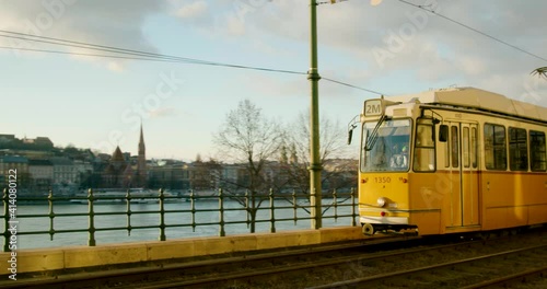 Yellow trams passing the rails in the sunset.