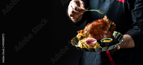Roasted pork knuckle eisbein with sauerkraut, mustard and rosemary. Oktoberfest, traditional German cuisine. banner, catering menu recipe. Long banner format place for text