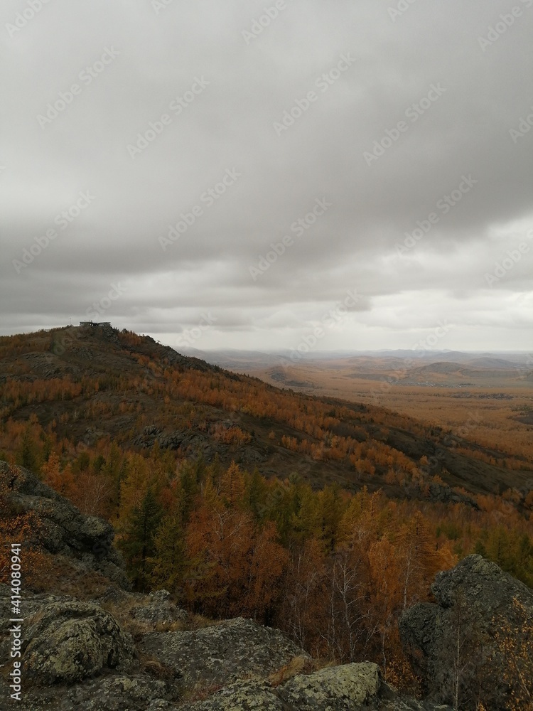 Mountain gorge in autumn. Rocks, mountains, orange trees.