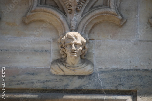 Detail of a face carved in white marble on the main facade of Milan Cathedral (Italy)