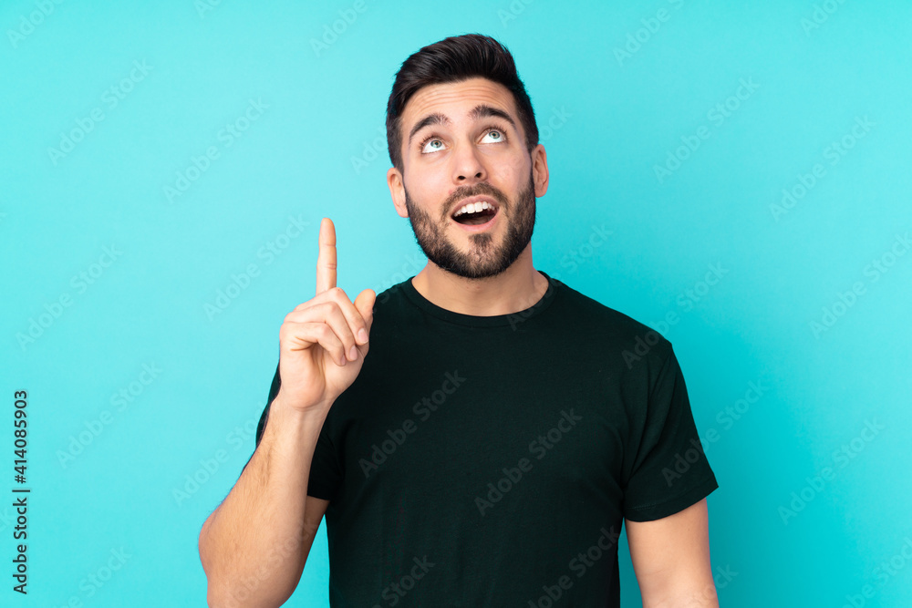 Caucasian handsome man isolated on blue background thinking an idea pointing the finger up Caucasian handsome man isolated on blue background thinking an idea pointing the finger up