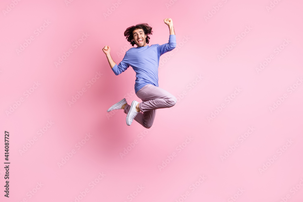 Full size photo of young happy joyful smiling crazy positive man jump in victory isolated on pink color background Full size photo of young happy joyful smiling crazy positive man jump in victory isolated on pink color background