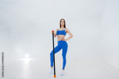 Sexy young girl performs sports exercises on a white background. Fitness, healthy lifestyle