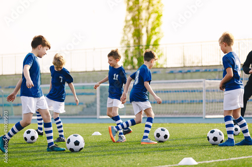 Football Education for Kids. Physical Education for Children. Young Coach With Kids in Soccer Team on Training Unit. Youth Team Coach Training School Boys in Football Soccer © matimix