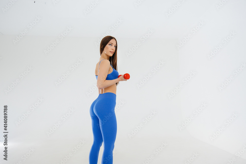 Sexy young girl performs sports exercises on a white background. Fitness, healthy lifestyle Sexy young girl performs sports exercises on a white background. Fitness, healthy lifestyle