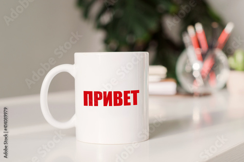 The word Hello on russian language written on white coffee cup
