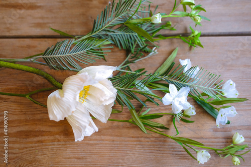 Fototapeta Naklejka Na Ścianę i Meble -  Spring white flowers with green leaves on a wooden table